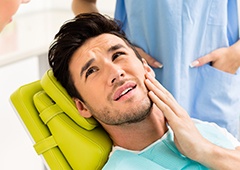 Man holding jaw in pain
